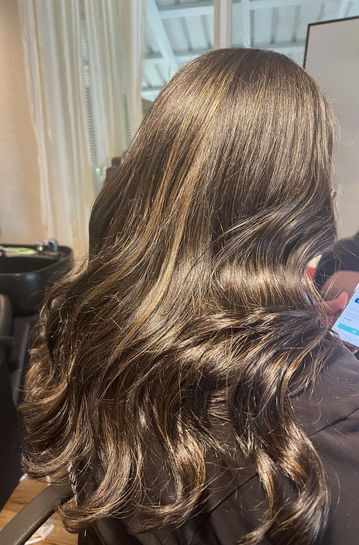 Long brunette hair styled in glossy, loose waves